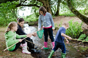 Schoolchildren playing in the stream at Dunfield House